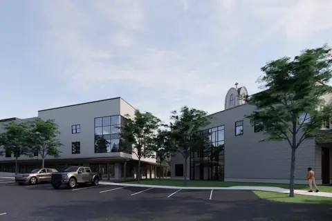 A rendering of the entrance canopy on the long youth centre building, with cars parked in front of it.