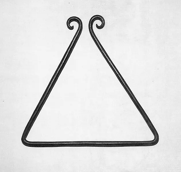 A plain iron triangle with the two ends curled into spirals, photographed against a light ground.